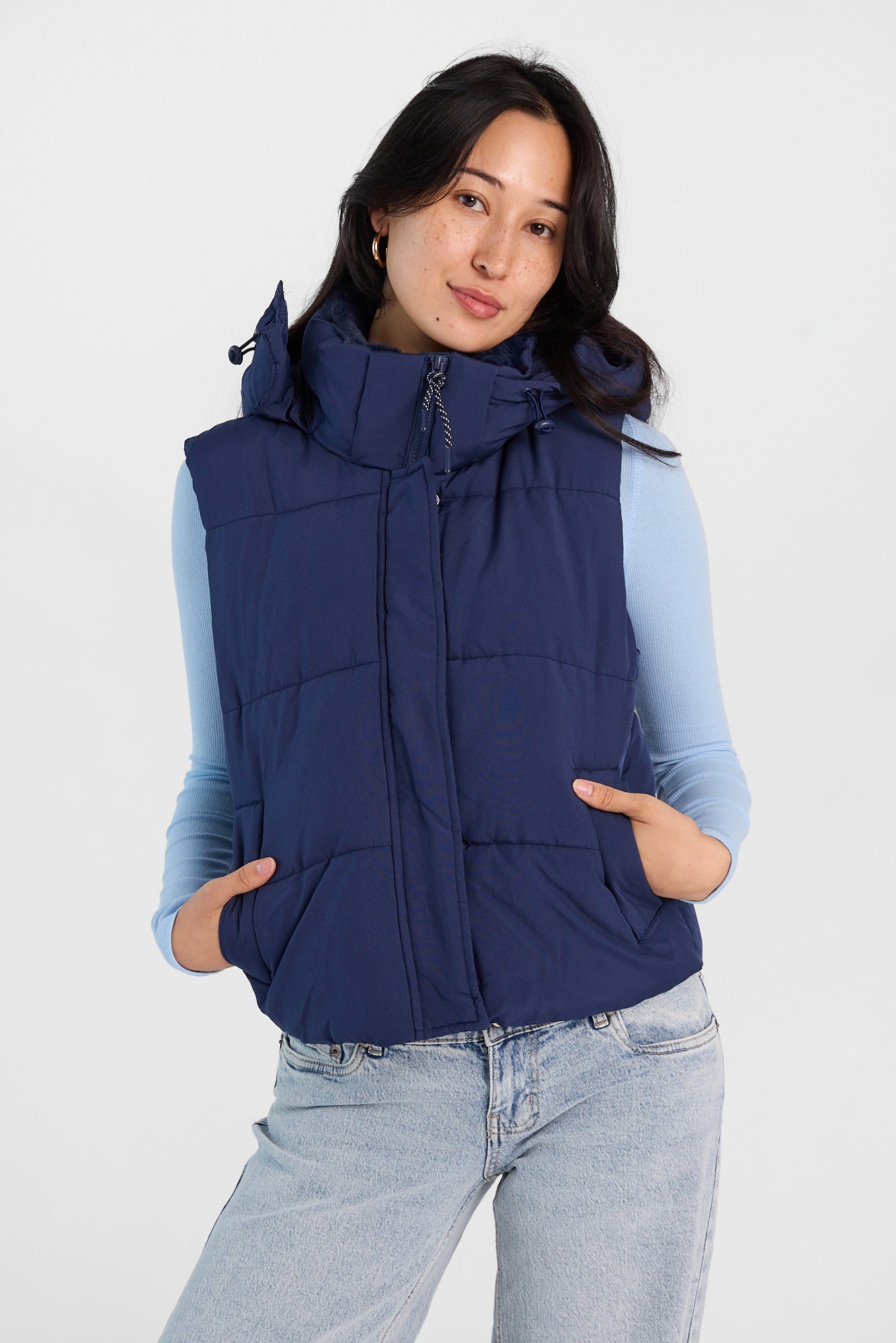 Model wearing a navy puffer vest